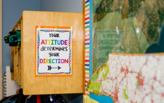 classroom sign that reads "your attitude determines your direction"