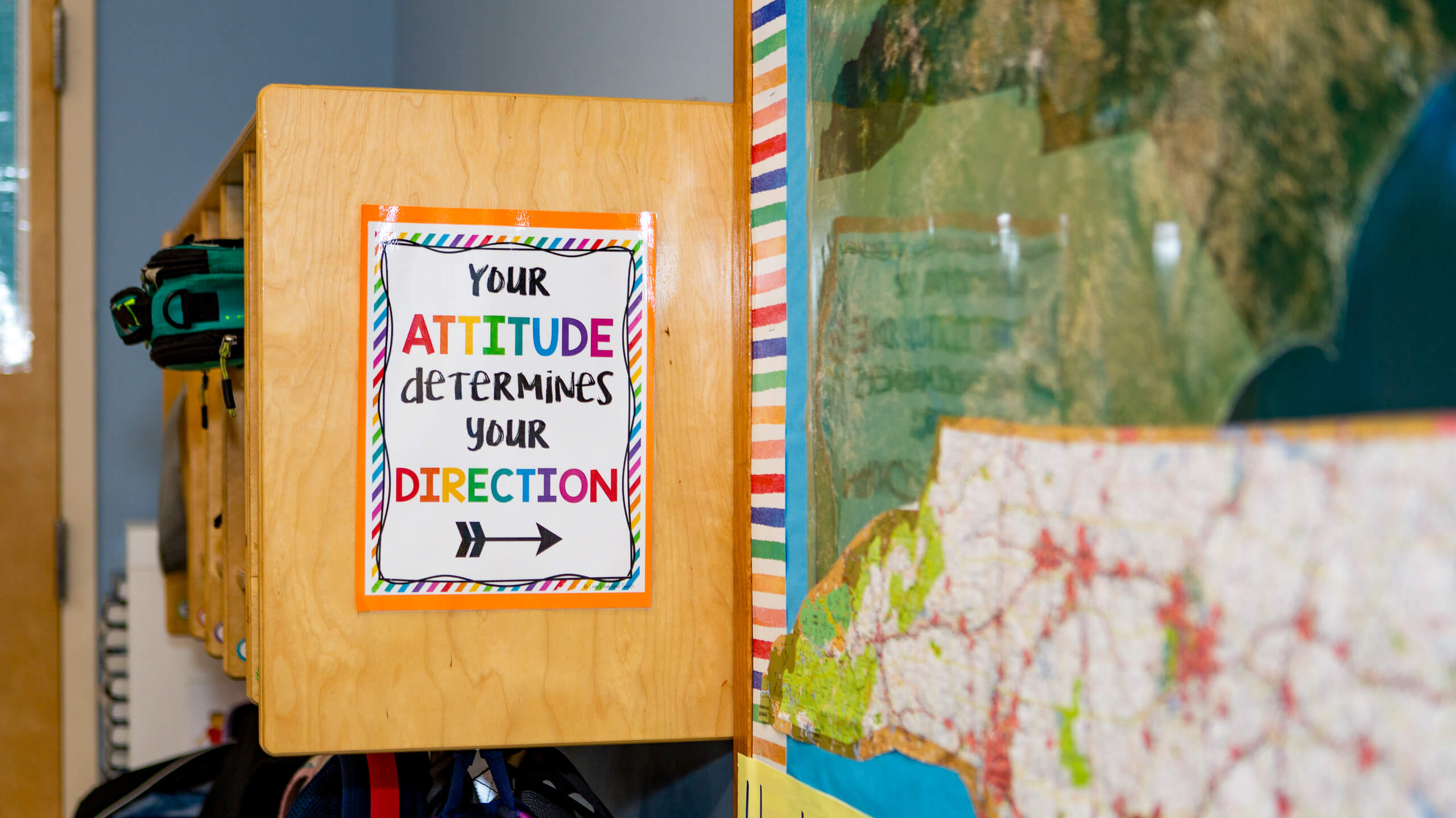 classroom sign that reads "your attitude determines your direction"