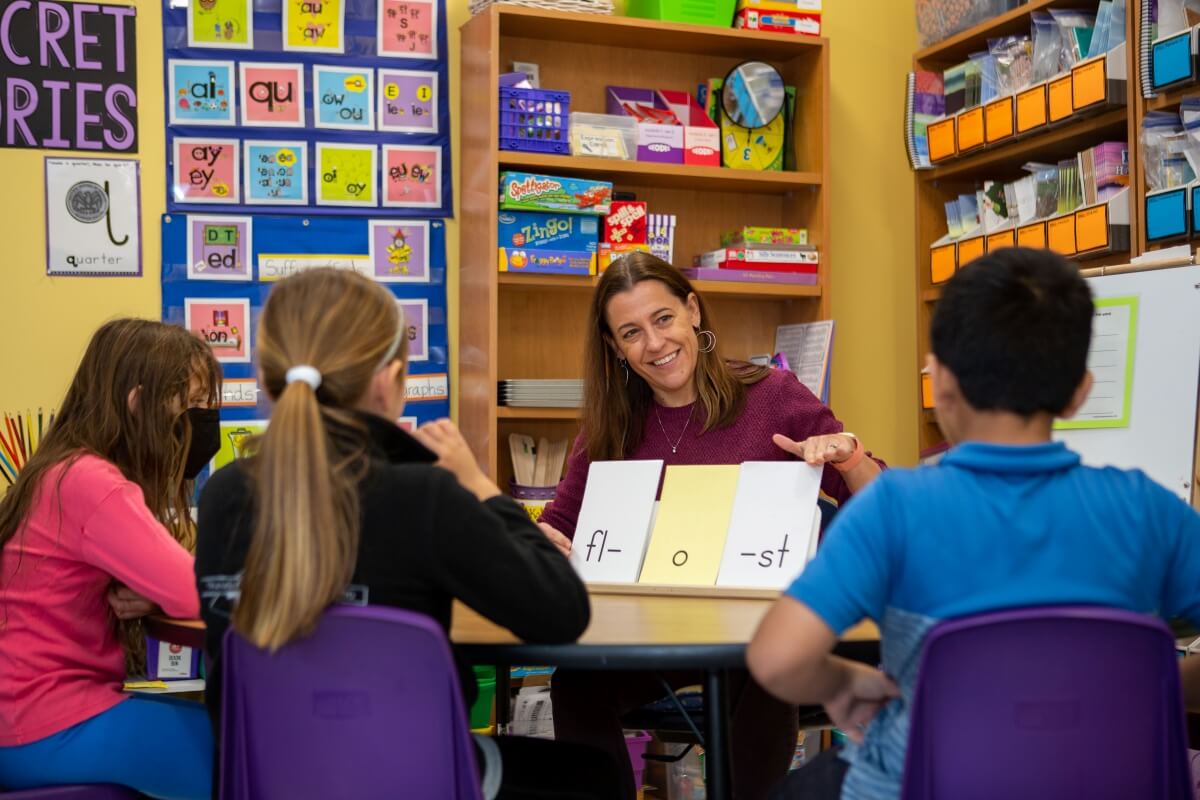 Jenn Phillips leads a small group literacy instruction with three Lower School students